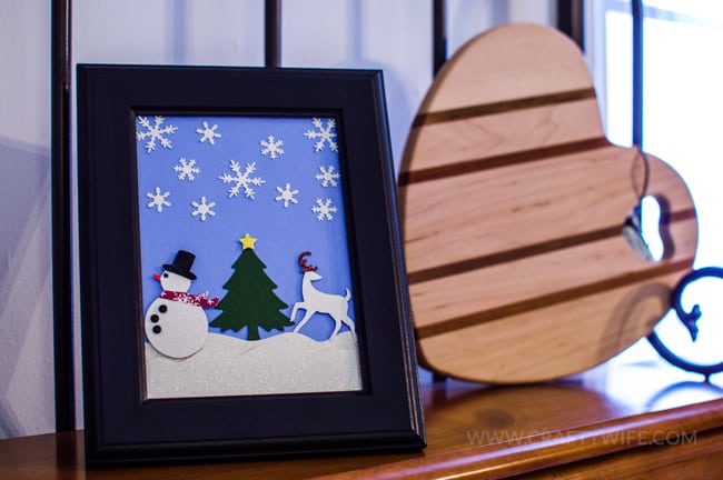 Use paper crafts to create a winter wonderland picture display for your home. Use a snowman hole punch and other paper craft items to create the scene.