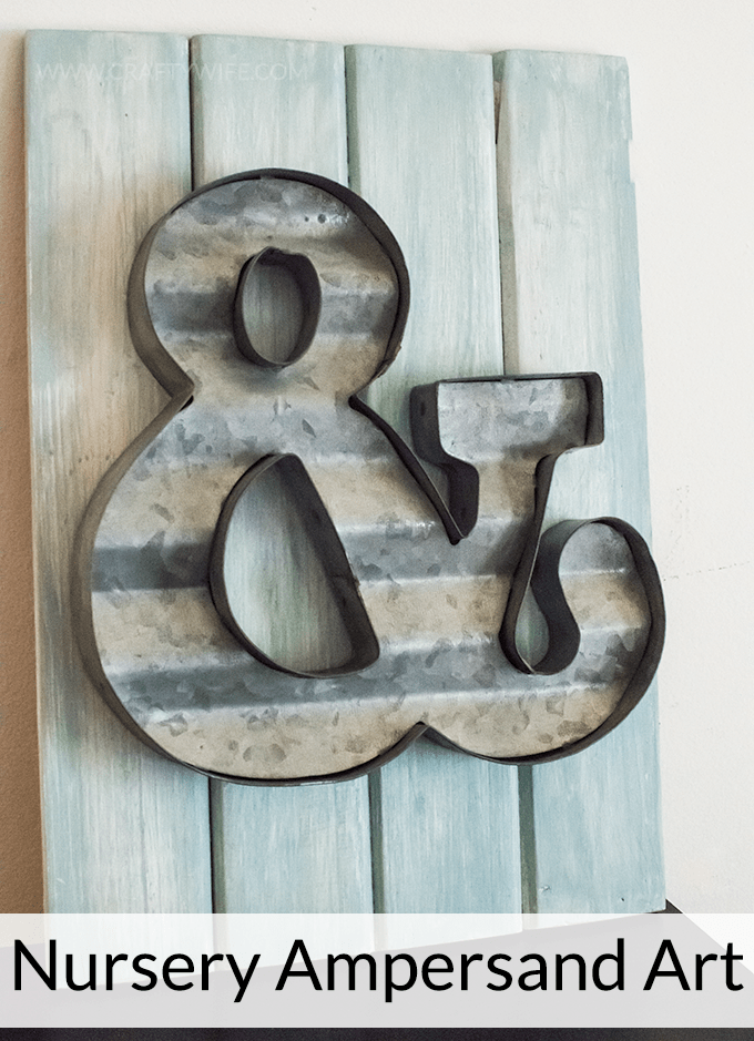 Create an easy art display with a metal ampersand and wooden board from Michaels Arts & Craft store. Perfect decor for a nursery or a gallery wall!