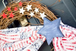 Welcome friends & family to your home all summer long with this simple Patriotic wreath! Made with stars & stripes fabric, wooden stars, & a grapevine base.