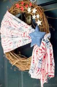 Welcome friends & family to your home all summer long with this simple Patriotic wreath! Made with stars & stripes fabric, wooden stars, & a grapevine base.