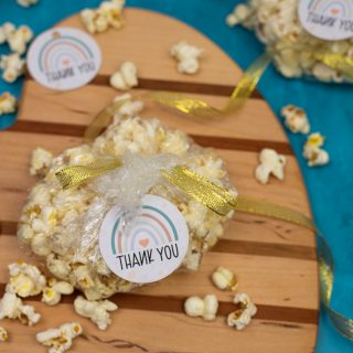 gender neutral baby shower gift tags tied to bags of fresh popcorn