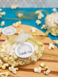 gender neutral baby shower gift tags tied to bags of fresh popcorn