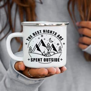 Circle with the words the best nights are spent outside around the outside of it. And on the inside there are mountains, trees, a tent and a fire